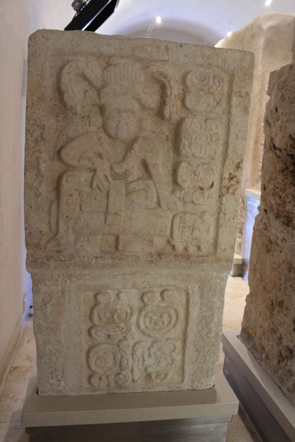 Panel con personaje sentado en un trono e inscripciones