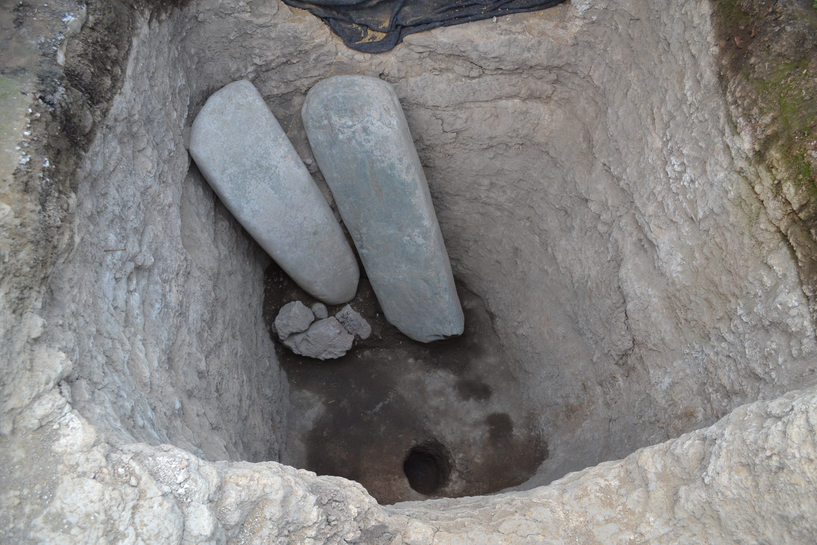 Dos monolitos de piedra verde localizados en una de las fosas al interior de la Estructura A